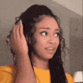 a woman is holding her hair in a ponytail and making a funny face .