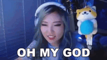 a woman is wearing headphones and holding a stuffed animal and saying `` oh my god '' .