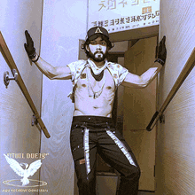 a shirtless man is standing in a hallway with a sign that says ' devil duets ' on the bottom right