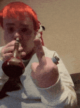 a man with red hair is smoking a pipe and giving the middle finger