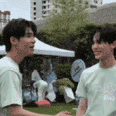 two young men are standing next to each other and one of them is wearing a t-shirt that says golf