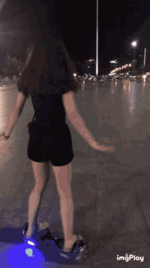 a woman riding a hover board with a blue light on the wheels