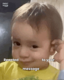 a baby is making a funny face while holding his hand to his ear and saying `` reacted to your message '' .