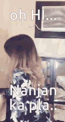 a woman is standing in front of an air conditioner and says oh hi nanjan ka pla .