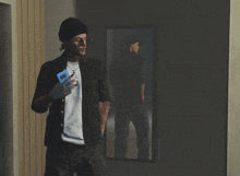 a man standing in front of a mirror holding a blue phone that says ' samsung ' on it