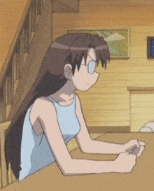 a girl wearing glasses sits at a table in a room