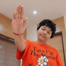 a person wearing an orange shirt that says turn up the music on it