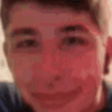 a close up of a young man 's face with a red spot on his forehead .