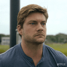 a man wearing a blue shirt that says netflix on the back