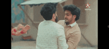 a couple of men are standing next to each other with a star plus logo in the corner