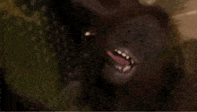 a close up of a monkey with its mouth open and teeth showing .
