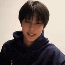 a close up of a young man wearing a blue hoodie .
