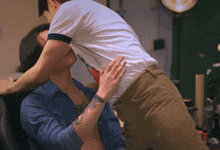 a man with a tattoo on his arm is holding another man 's back