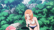 a girl in a bikini stands next to another girl in a pink shirt