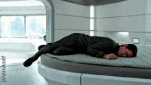 a man is laying on a round bed with the name prassant written on the bottom