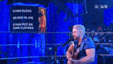 a man playing a guitar in front of a screen that says ' ethan sucks believe in joe '