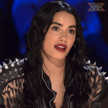 a woman in a leopard print jacket with spikes on the sleeves