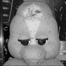 a black and white photo of a stuffed animal that looks like a horse .