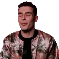 a man with his eyes closed wears a pink jacket with leaves on it