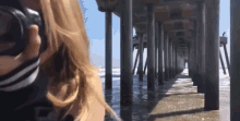 a woman is taking a picture of a pier with a canon camera