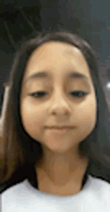 a close up of a young girl 's face with a blurred background .