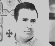 a black and white photo of a man looking at the camera
