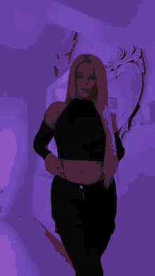 a woman in a black crop top is standing in front of a mirror