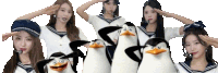 a group of penguins are standing next to a group of girls