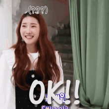 a woman with long red hair is smiling and the word ok is above her head