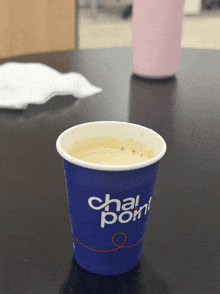 a cup of chai point sits on a black table