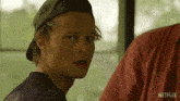 a man wearing a baseball cap and a shirt that says netflix on it