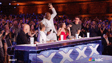 a group of people sitting at a table with a sign that says xxx on it