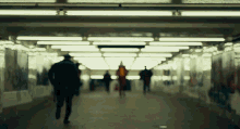 a blurred image of people walking down a tunnel