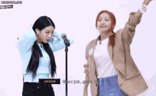 two girls are standing in front of a microphone and one of them says good job good job