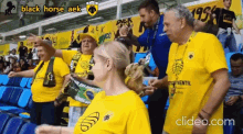 a group of people wearing yellow shirts that say black horse