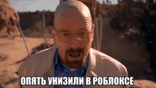 a bald man with glasses and a beard is standing in the desert with a caption in a foreign language