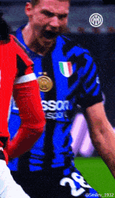 a soccer player wearing a blue and black jersey with the number 28