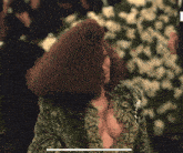 a woman with a very plunging neckline is standing in front of a bunch of flowers