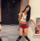 a woman is standing next to a fire extinguisher in a room .