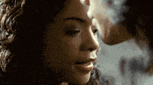 a close up of a woman 's face with a man 's face in the background