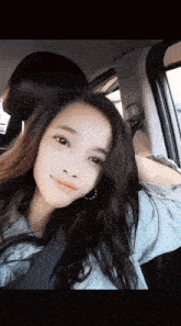 a woman sitting in a car with her head resting on the headrest