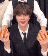 a man in a suit and tie is holding a sandwich in his hands .