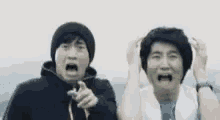 two men are standing next to each other making funny faces .
