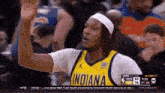 a basketball player wearing an indiana jersey waves his hand in the air