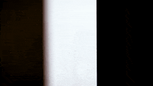 a person is holding a black object in their hand in the dark .