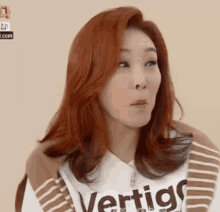 a woman with red hair wears a vertigo shirt