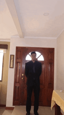 a man in a suit stands in front of a door