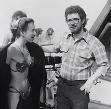 a black and white photo of a man and a woman in bikinis
