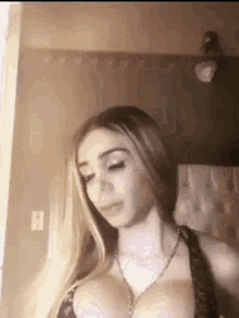 a woman with large breasts is standing in front of a mirror in a room .