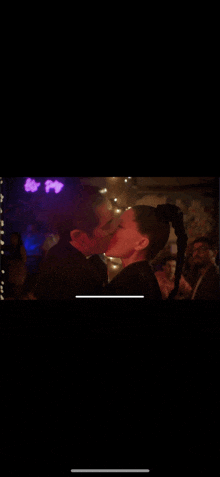 a man and woman kissing in a dark room